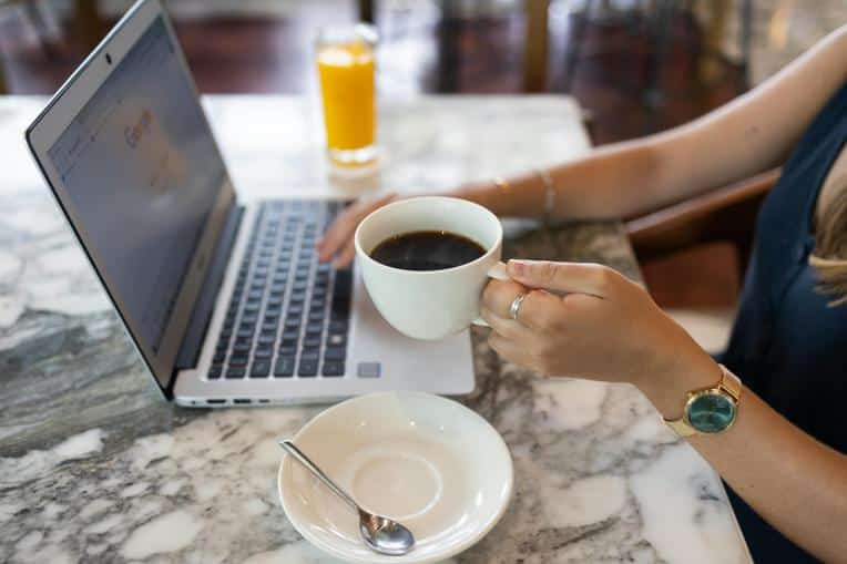 Person in a cafe using Google search on their laptop