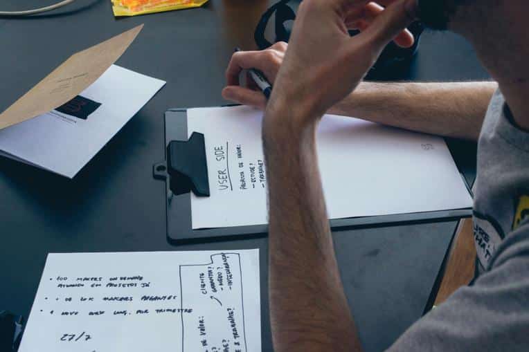 Person mapping out website UX on a clipboard